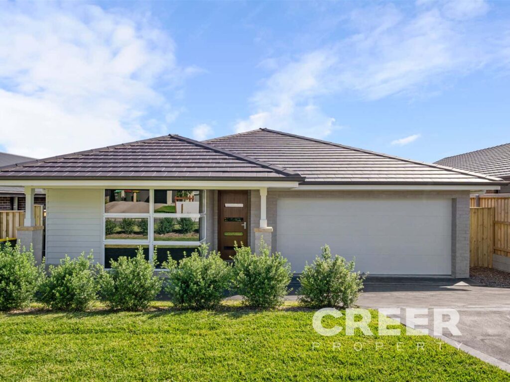 A modern, single-storey house with a brown tiled, hipped roof